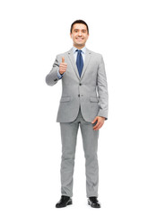 happy businessman in suit showing thumbs up