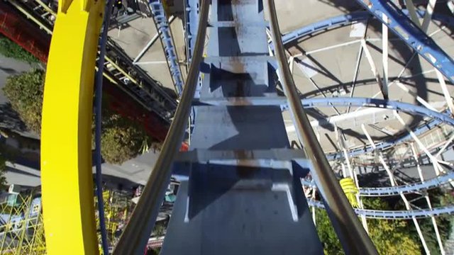 First person view of a roller coaster going up backwards a loop.