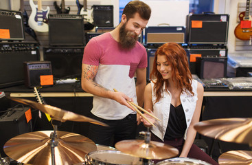 man and woman with drum kit at music store
