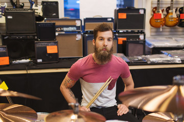 male musician with cymbals at music store