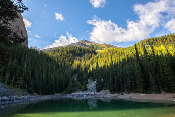 people a the the water's edge of mirror lake on the hiking trail big beehive of the banff national park in the rocky mountains of alberta canada