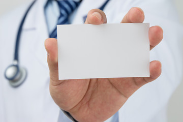 Doctors hand holding a business card