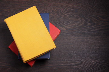 Books on a dark wooden table, the top view.