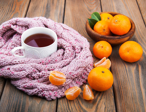 Cup of tea with scarf and tangerines
