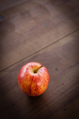 Apple on Wooden Surface; vertical image
