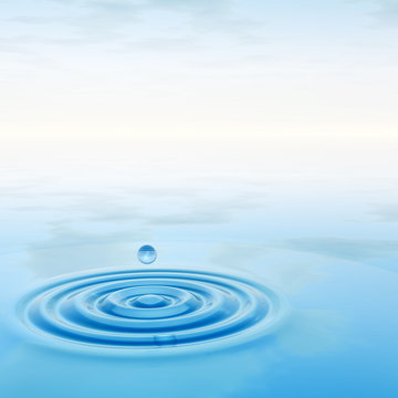 Conceptual blue liquid drop falling in water