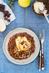 Chocolate risotto served with caramelized onion rings and caramelized pear slices