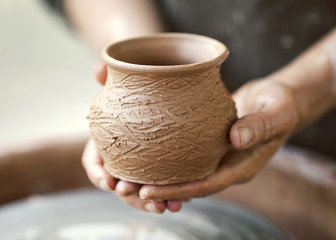 Fototapeta na wymiar Hands working on pottery wheel