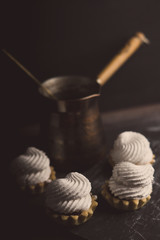 Creamy cake on the dark rustic background. Shallow depth of field. Toned image.