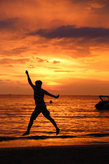 Silhouette of the man, jumping on the beach