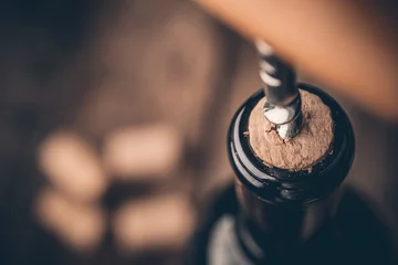 Foto op Plexiglas Kurkentrekker en fles wijn op het bord © poplasen