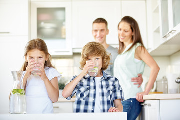 Kinder trinken frisches Wasser mit Limetten