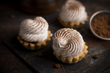 Creamy cake on the dark rustic background. Shallow depth of field.