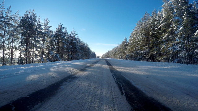 Movement of the car in the winter. A driving on snow road, to a clear sunny day. 
