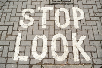 stop-look written sign on pavement made of bricks