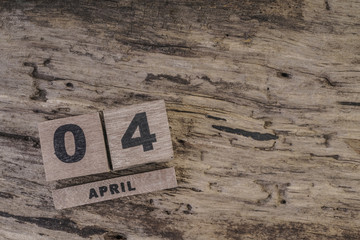 cube calendar on wooden surface for april with copy space