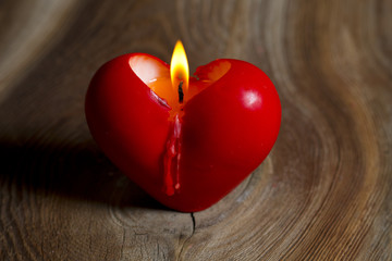 Świeczka w kształcie serca na drewnianym tle