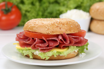 Bagel Brötchen zum Frühstück belegt mit Salami Schinken