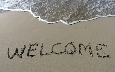 Fototapeta premium Inscription Welcome on wet sand. 