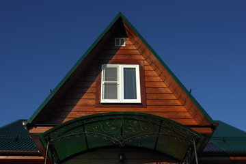 Green metal roof  and white attic window