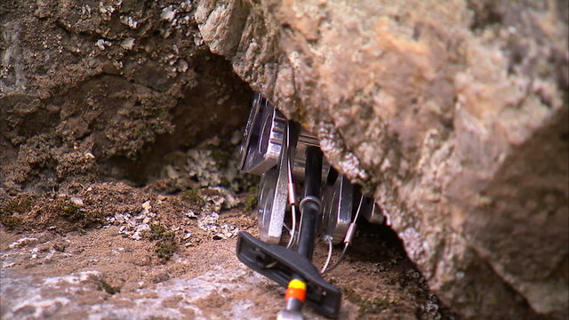Shot of a camming device placed into a crack in the rock.