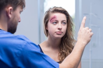 Doctor diagnosing injured woman