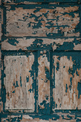 Details of peeling paint on an old green door; vertical image