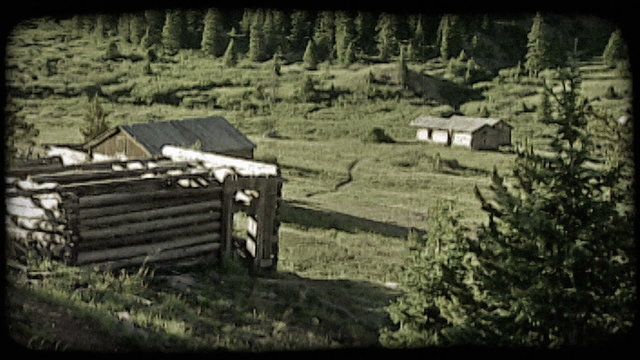 Old cabin in mountains. Vintage stylized video clip.