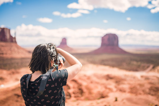 Tourist photographer woman taking pictures photo in Monument Valley, Arizona, USA. Young woman on travel in United States.