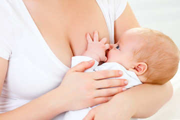 Obraz na płótnie Canvas breastfeeding. mother holding newborn in embrace and breastfeed