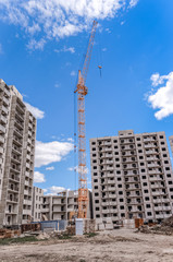 Fototapeta na wymiar Hoist crane and construction of new apartments