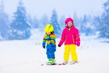 Fototapeta na wymiar Two children skiing in snowy mountains
