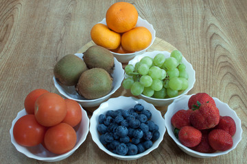 Six bowls filled with fruit displayed on a tabletop