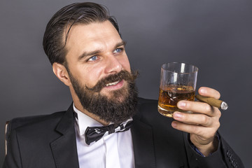 Portrait of a happy young man with retro look sitting in an armc