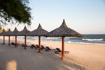 Sonnenschirme und Strandliegen am Meer vor Vietnam