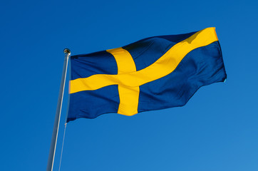Flag of Sweden against the blue sky, national patriotic background
