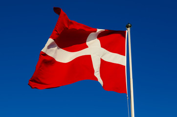 Naklejka na ściany i meble Flag of Denmark against the blue sky, national patriotic background