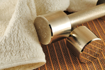 Dumbbells and terry towel on bamboo mat