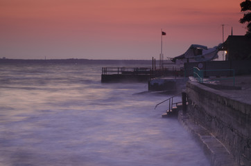 Sea sunset pink  landscape with pier and blurred water, natural seasonal holiday background