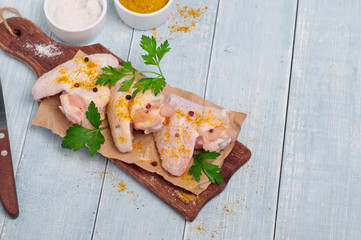 Fresh raw chicken wings on chopping board