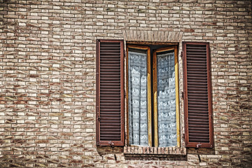 window in a brick wall in Siena