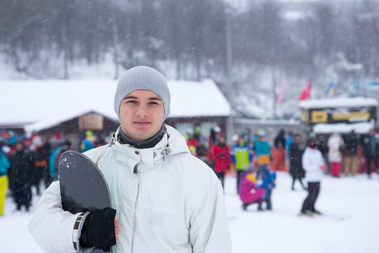 Attractive young man with his snowboard