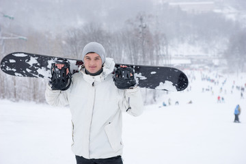 Smiling friendly young male snowboarder