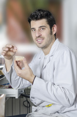 Dental technician with a dental model in his hand.