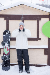 Young man with his snowboard drinking coffee