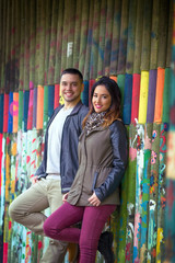 Young couple posing against colorful wooden background