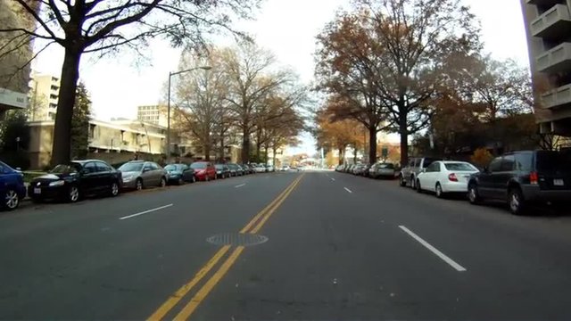 A handheld shot of driving down a straight street in Washington DC on a cloudy day.