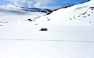 Eingeschneite Hütte in einem einsamen Gebirge in Norwegen 