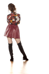 back view of attractive brunette in a leather skirt and boots