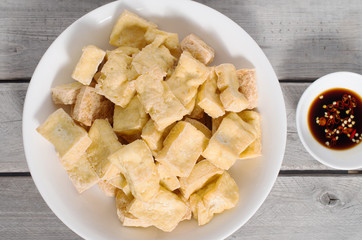 Dee fried tofu cubes on a wooden table, a favorite meal for vege